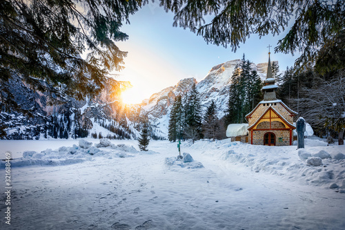 Valokuva Beautiful Alpine winter landscape with a little church in the snow and morning s