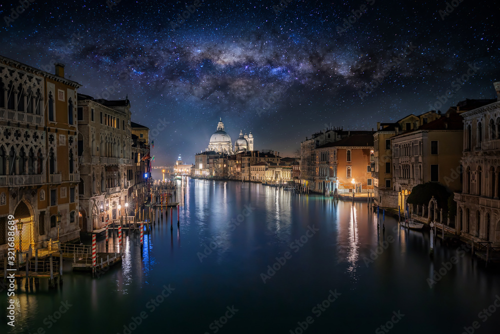 Konzept von Venedig bei Nacht mit den beleuchteten Häusern am Kanal Grande und der Milchstraße im Himmel, Italien