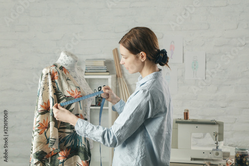 Foto Tailor adjusts garment design on mannequin in workshop - fashion atelier, slow f