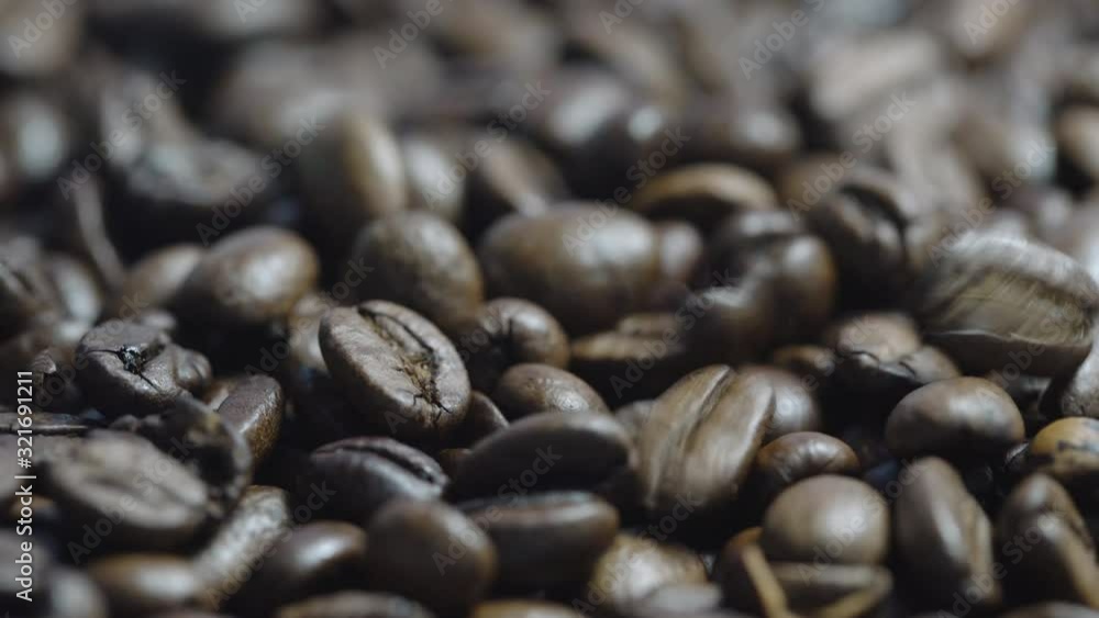 tasty roasted coffee beans of brown colour fall on large heap and reflect electric light extreme close view tasty roasted coffee beans of brown colour fall on large heap and reflect electric light extreme close view