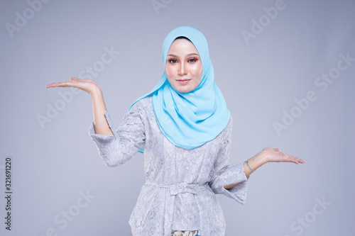 Beautiful female model in various poses wearing modern kebaya and hijab, a urban lifestyle apparel for Muslim women isolated on grey background. Beauty and hijab fashion concept. Half length.
