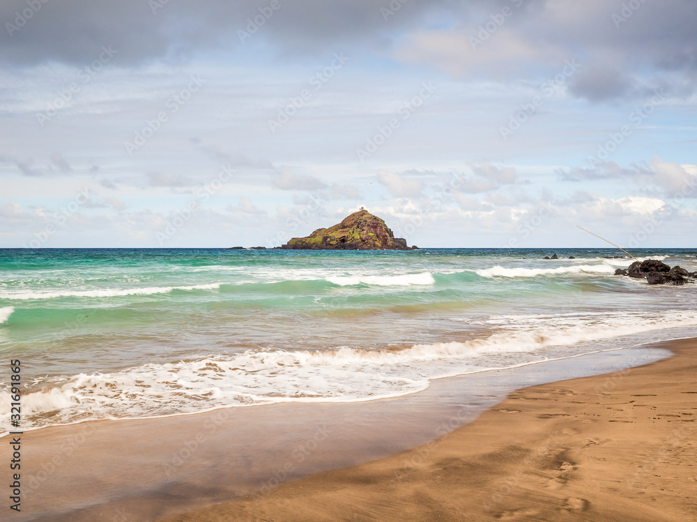 Fototapeta premium Koki Beach Park Maui. The dark red sand at Koki Beach was produced by the nearby cinder cone hill of Ka Iwi O Pele. Koki Beach is one of two famous Hana surf breaks and favorite spot for local surfers