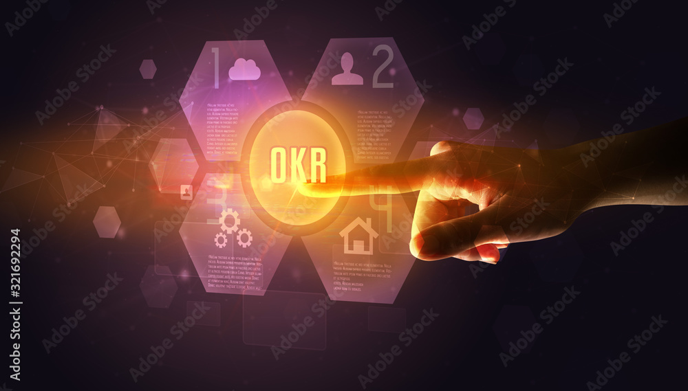 Hand touching OKR inscription, new technology concept Hand touching OKR inscription, new technology concept