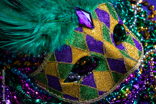 Fotografiet Colorful Mardi Gras mask on purple background with beads