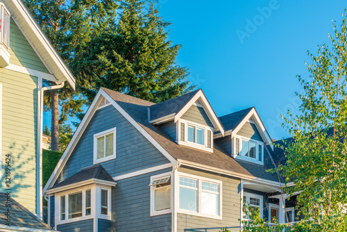 A perfect neighborhood. Houses in suburb at Summer in the north America. Top of a luxury house with nice window over blue and white sky.