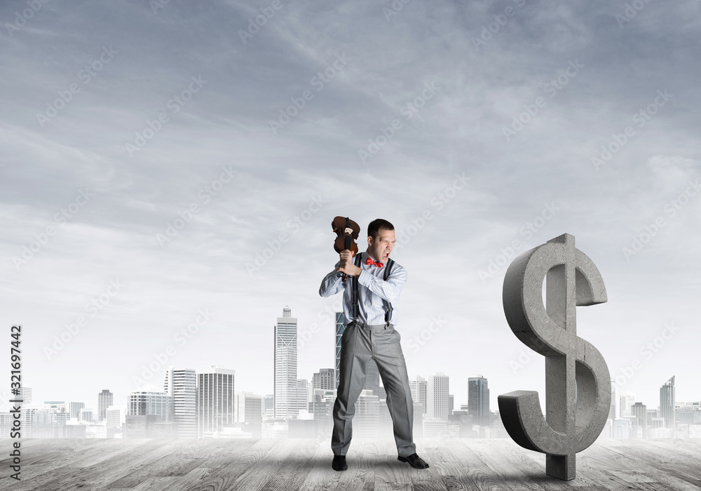 Determined banker man against modern cityscape breaking dollar concrete figure Determined banker man against modern cityscape breaking dollar concrete figure
