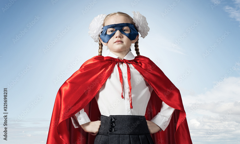 Girl power concept with cute kid guardian against sky background Girl power concept with cute kid guardian against sky background
