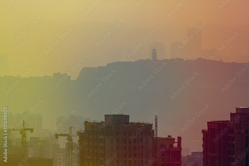 Blurred cityscape in sunset haze. Chinese city of Chongqing. China. For a beautiful background, postcard, banner.