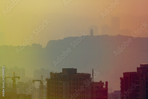 Blurred cityscape in sunset haze. Chinese city of Chongqing. China. For a beautiful background, postcard, banner.