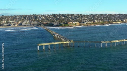 Iconic Yellow Bridge Over The Big Blue Sea At Ocean Beach Pier In San Diego, California - Aerial Shot photo