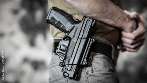 Man openly carrying a pistol on his belt. Open carry and second amendment concept.