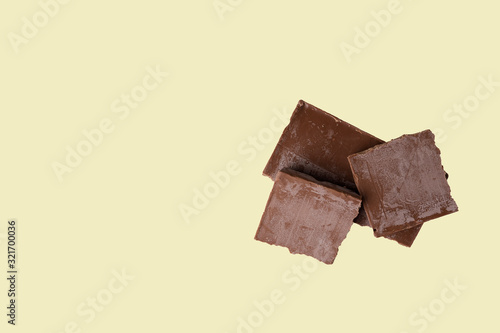 spoiled broken chocolate bar covered with white coating on an isolated light background. greasy chocolate