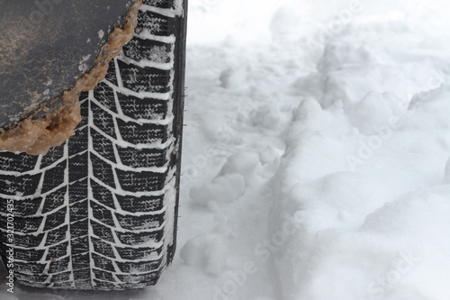 A car wheel with a winter tread stands in the snow. © Игорь Салов