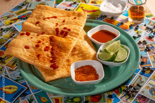 Botana tradicional mexicana durito chicharrón con chile limón y sal adornado con juego de lotería mexicana photo