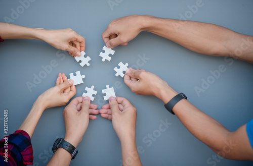 A high-level view of business people who solve puzzles On a gray background