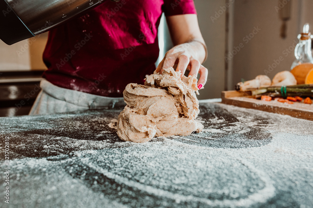 .Young woman kneading bread in her home kitchen. No culinary skills and all flour stained in the kitchen. Having fun. Close up. Lifestyile