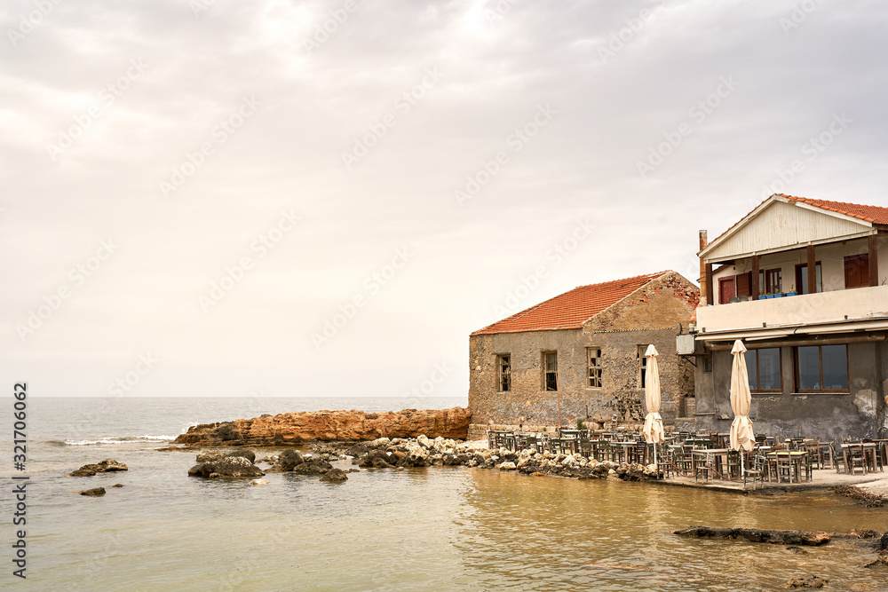 Obraz premium Chania, Crete, Greece. May 20, 2019. Restaurant along the shore of The Venetian Harbour in Chania western Crete.