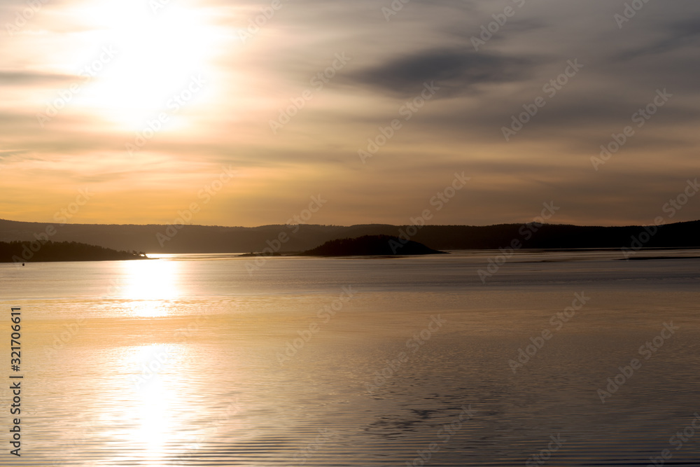 Sonnenaufgang auf dem menschenleeren Oslofjord bei bedecktem Himmel