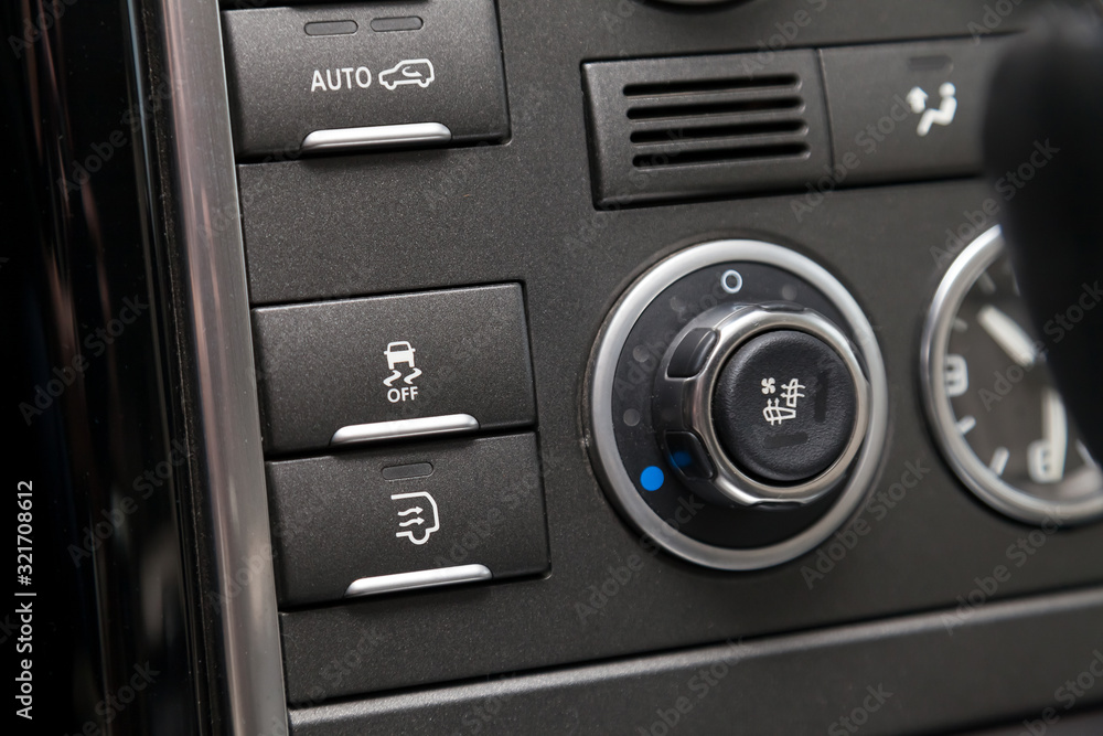 The button for the stability control system, side mirrors adjust headlight washer on black panel of car near the steering wheel to overcome off-road, impassable roads and drive safely in snow or rain The button for the stability control system, side mirrors adjust headlight washer on black panel of car near the steering wheel to overcome off-road, impassable roads and drive safely in snow or rain