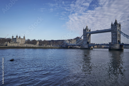 Landscape Picture of Tower bridge over Thames river and Tower castle in heart of London  taken in sunny spring day. Beautiful example of two historic architectural styles in capitol of United Kingdom.