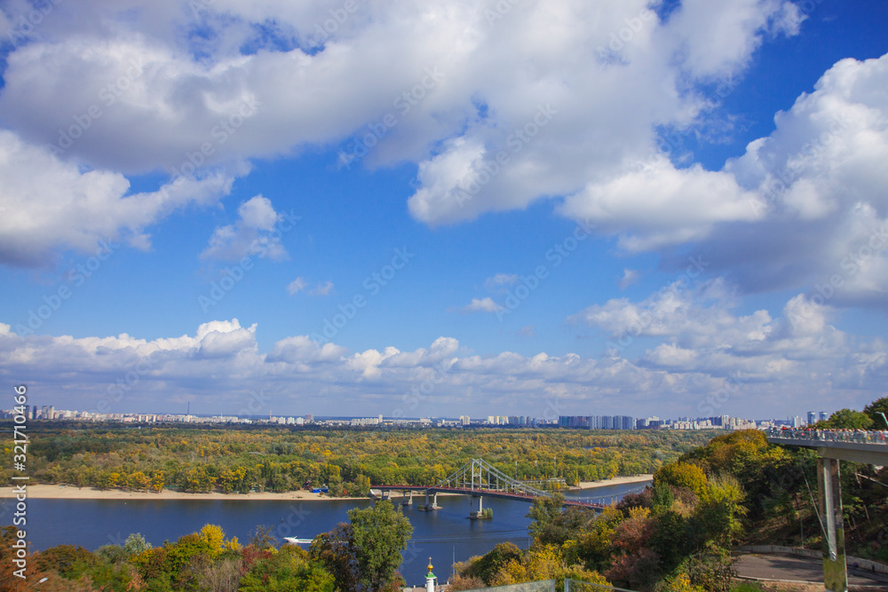 Obraz premium City of Kiev, Ukraine. City landscape overlooking the Dnieper river, parks and builds. Fluffy clouds and sunny autumn day.