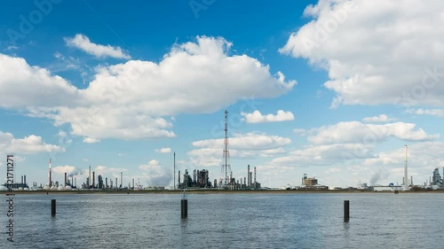 Zooming timelapse sequence of large oil refineries in the harbor of Antwerp, Belgium with blue sky and mixed shadow and sunlight in 4K.