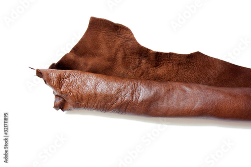 Leather in roll isolated on white background. Piece of brown leather isolated on white