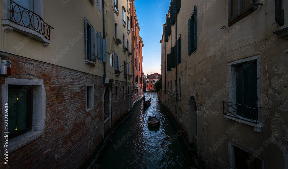 Everyday life of a gondolier. Walking on the bridges of the old city of Venice. Bright sun. The beauty of the ancient city. Italy.