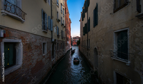 Everyday life of a gondolier. Walking on the bridges of the old city of Venice. Bright sun. The beauty of the ancient city. Italy.