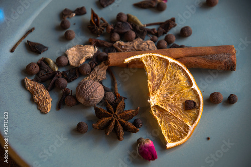 Dried oriental spices for making drinks on a home ceramic plate. Home kitchen.