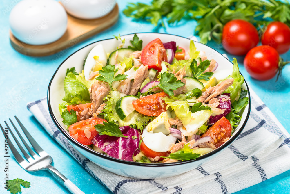 Tuna salad with green leaves, eggs and vegetables.