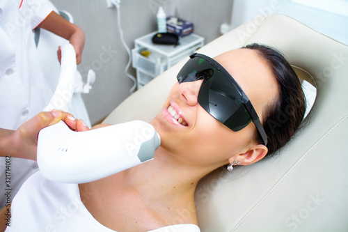 Close-up photo of the patient on the procedure for hair removal with a laser on the face. Satisfied patient.