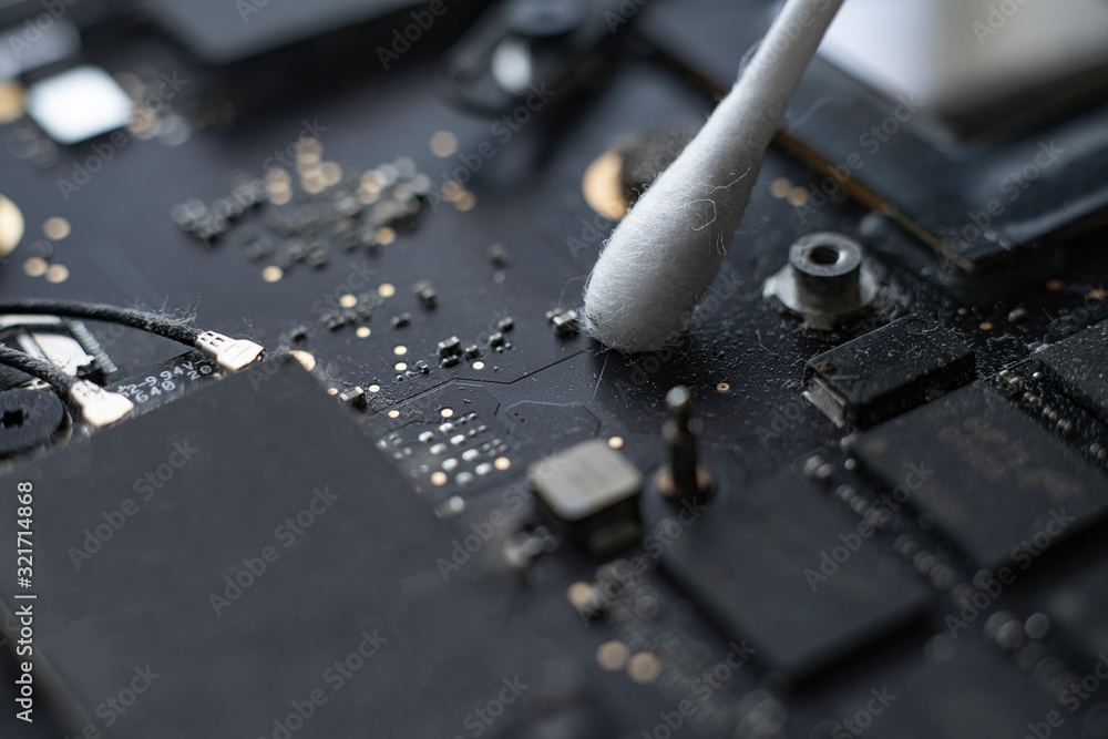 macro view of removing dust from microprocessor board using the cotton bud macro view of removing dust from microprocessor board using the cotton bud