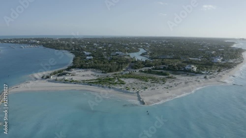 Aerial view of the beach with turquoise ocean on Turk and Caicos Caribbean Island, Providenciales. Flying above the ocean, white beach, turistic resort. Drone footage from left to right photo