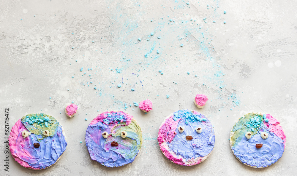 Cute toasts with colorful cream cheese spread on a light grey stone background. Ideas for kid’s food. Copy space, top view. Cute toasts with colorful cream cheese spread on a light grey stone background. Ideas for kid’s food. Copy space, top view.
