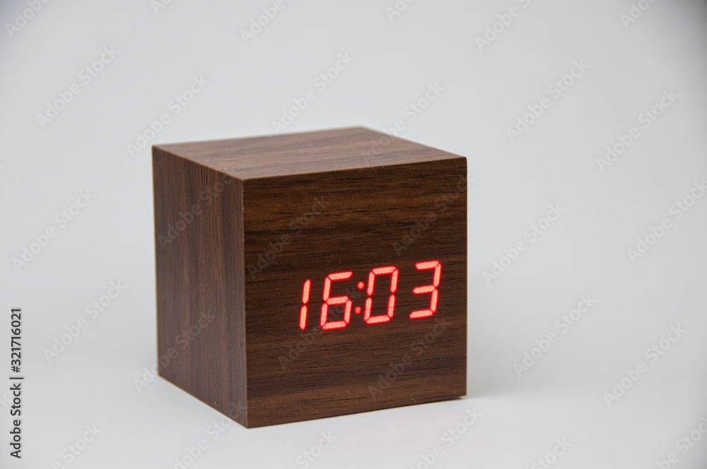 Wooden alarm clock on a white background showing time 16:03 Wooden alarm clock on a white background showing time 16:03