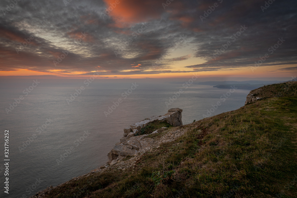 Beautiful vibrant sunset over sea and clifftop