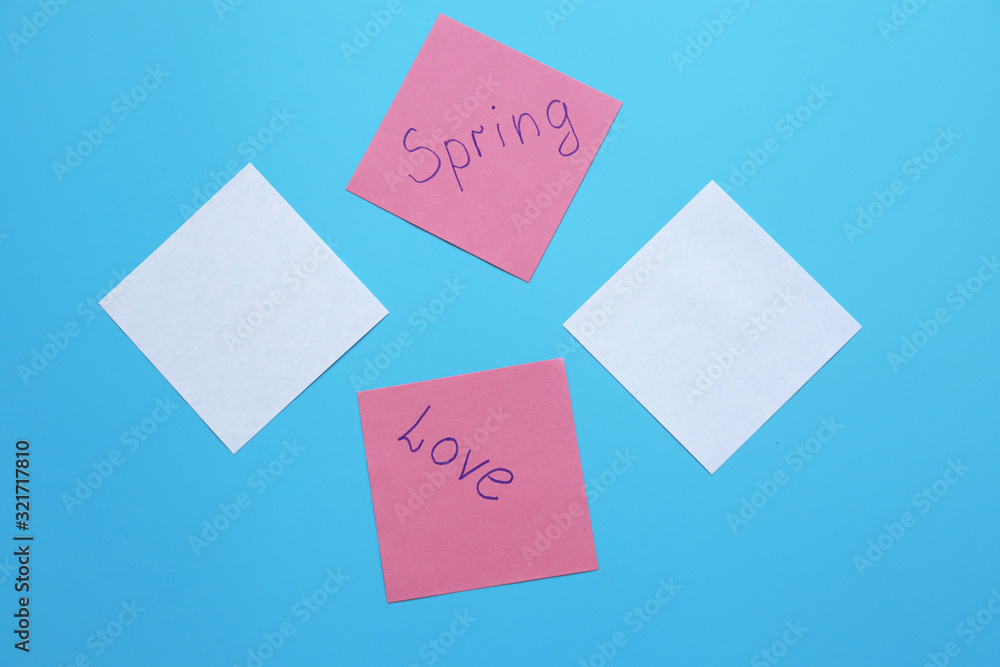 papers with the inscriptions love, spring on a blue background. copy space papers with the inscriptions love, spring on a blue background. copy space