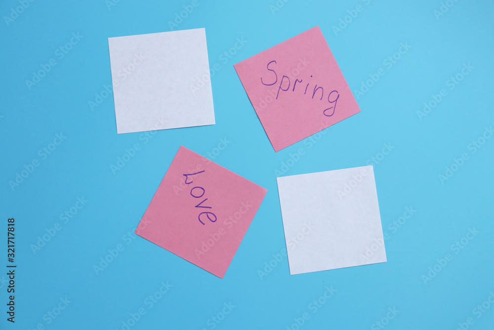 papers with the inscriptions love, spring on a blue background. copy space papers with the inscriptions love, spring on a blue background. copy space