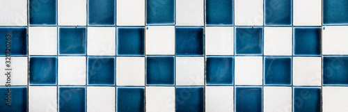 Old blue white checkered square vintage tiles wall background texture