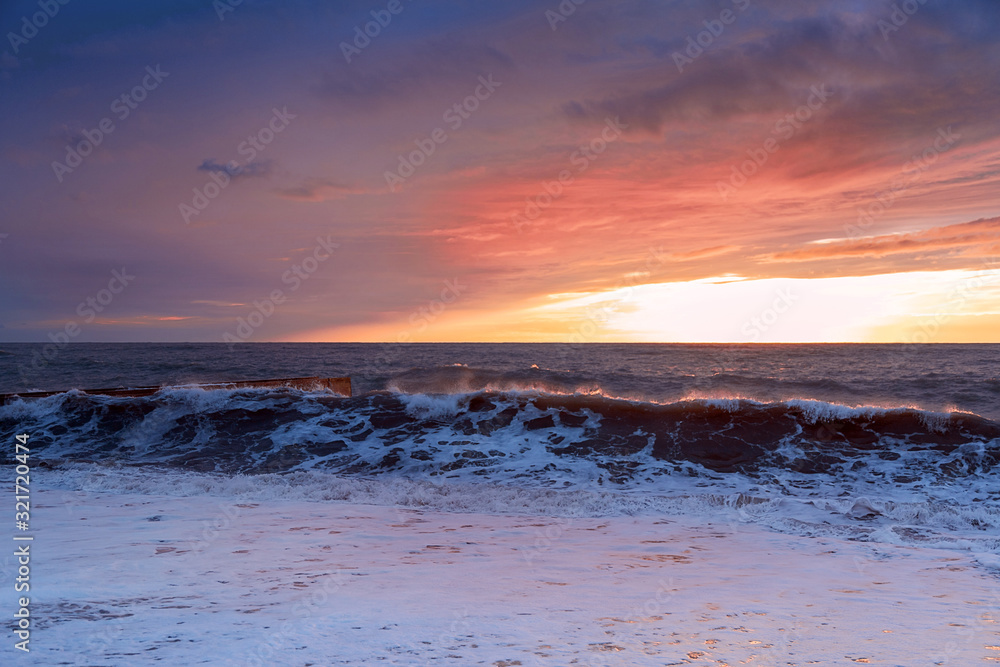 Obraz premium The evening sea is stormy. Sea sunset. The violence of the elements. Sea foam. Incredibly beautiful colors.