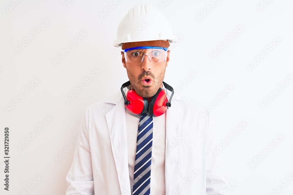Young chemist man wearing security helmet and headphones over isolated background afraid and shocked with surprise expression, fear and excited face. Young chemist man wearing security helmet and headphones over isolated background afraid and shocked with surprise expression, fear and excited face.