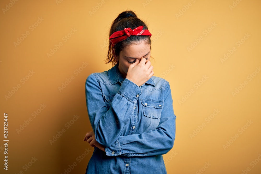 Young beautiful brunette woman wearing casual denim shirt and hair handkerchief tired rubbing nose and eyes feeling fatigue and headache. Stress and frustration concept. Young beautiful brunette woman wearing casual denim shirt and hair handkerchief tired rubbing nose and eyes feeling fatigue and headache. Stress and frustration concept.