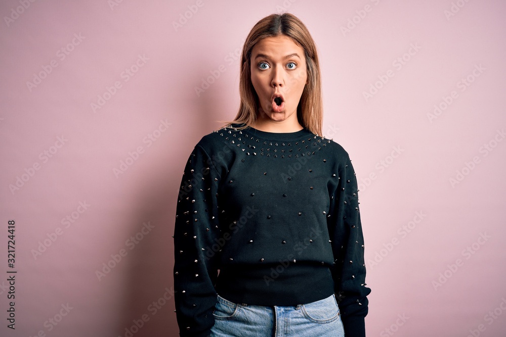 Young beautiful blonde woman wearing fashion sweater over pink isolated background afraid and shocked with surprise expression, fear and excited face. Young beautiful blonde woman wearing fashion sweater over pink isolated background afraid and shocked with surprise expression, fear and excited face.