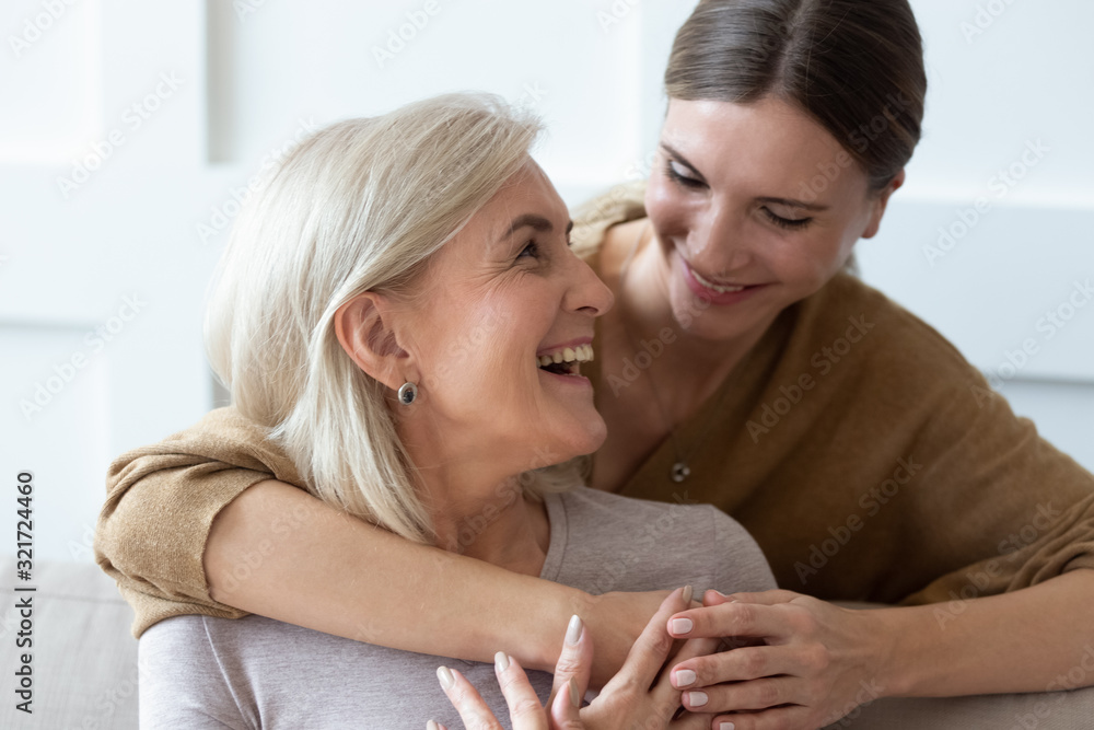 Grownup daughter hugging senior mom showing love and care Grownup daughter hugging senior mom showing love and care