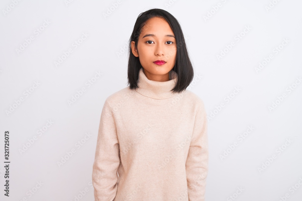 Young chinese woman wearing turtleneck sweater standing over isolated white background Relaxed with serious expression on face. Simple and natural looking at the camera. Young chinese woman wearing turtleneck sweater standing over isolated white background Relaxed with serious expression on face. Simple and natural looking at the camera.