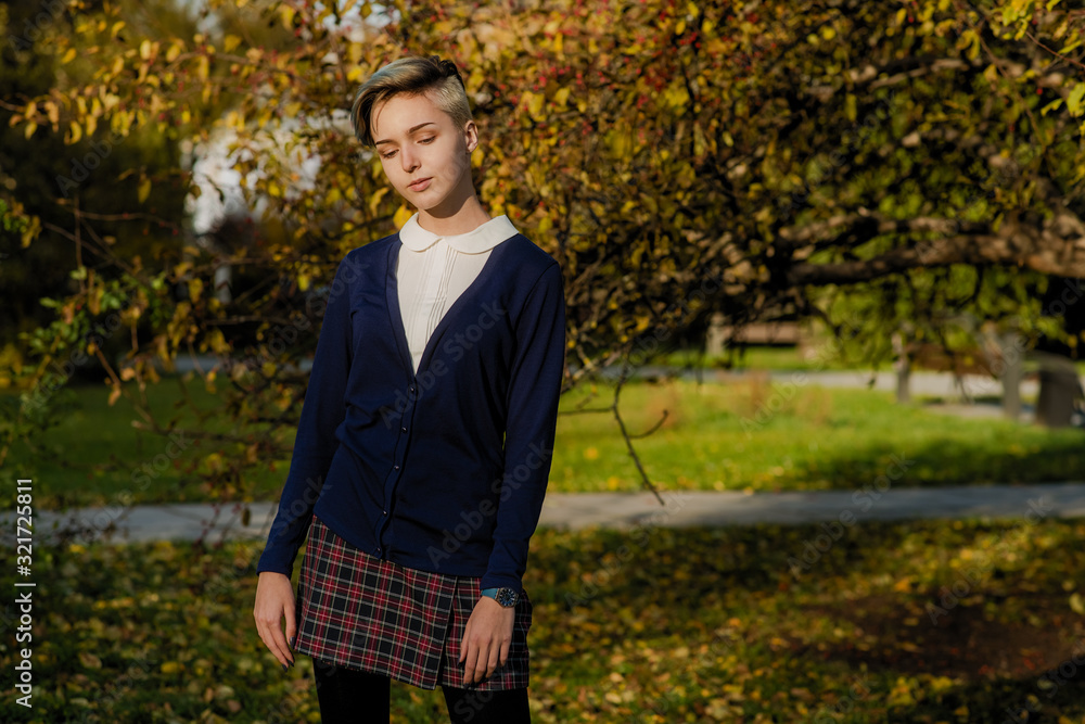 Trendy teen girl with short hair in autumn park Trendy teen girl with short hair in autumn park
