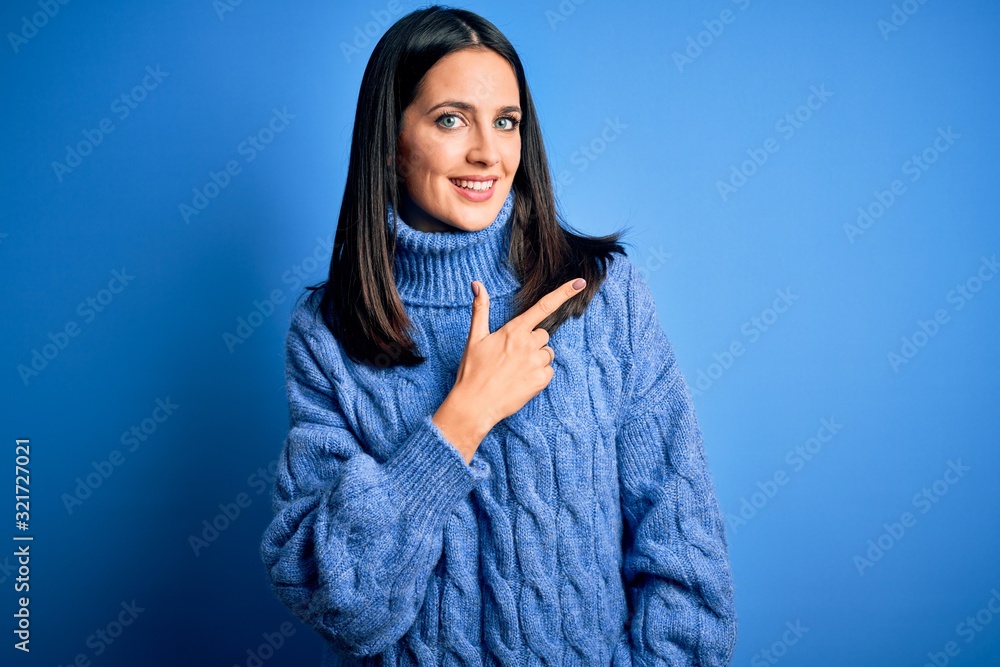 Young brunette woman with blue eyes wearing casual turtleneck sweater cheerful with a smile on face pointing with hand and finger up to the side with happy and natural expression Young brunette woman with blue eyes wearing casual turtleneck sweater cheerful with a smile on face pointing with hand and finger up to the side with happy and natural expression