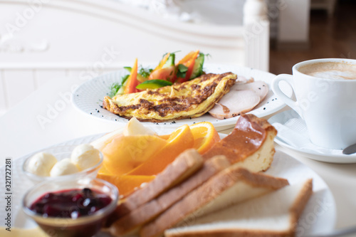 Close-up of tray with tasty breakfast on a bed.