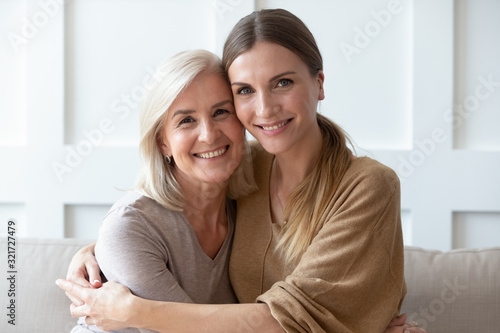 Headshot portrait of mature mom and adult daughter posing
